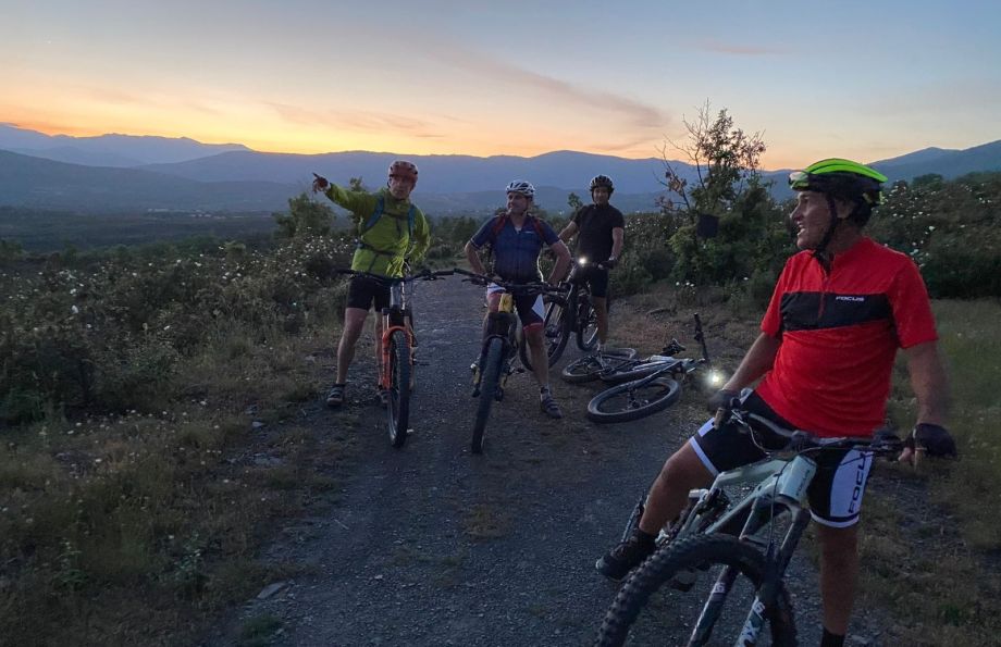 Grupo de ciclistas de montaña en el ocaso del día por el camino real