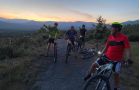 Grupo de ciclistas de montaña en el ocaso del día por el camino real